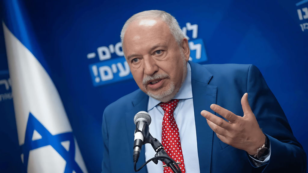 Avigdor Lieberman hablando en público frente a bandera israelí.