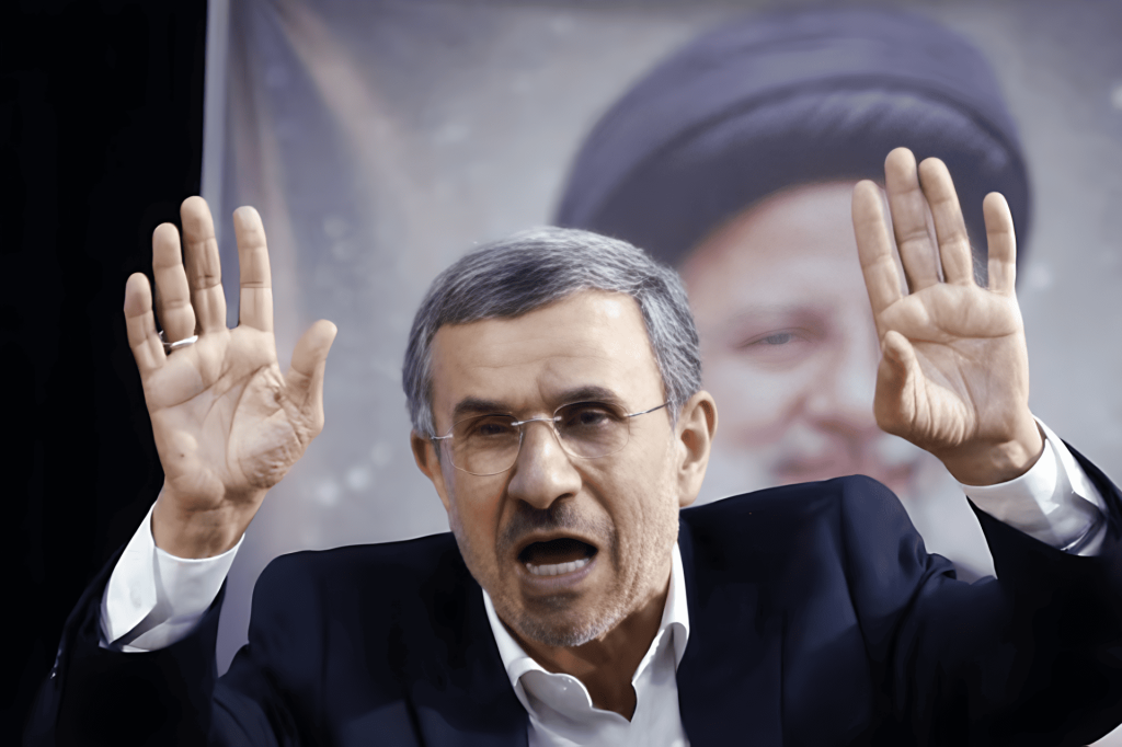 Mahmoud Ahmadinejad gesticulando con las manos levantadas en un evento.
