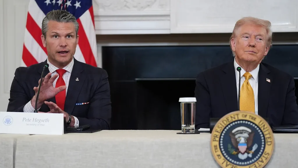 Pete Hegseth y Donald Trump en una reunión oficial con la bandera estadounidense.