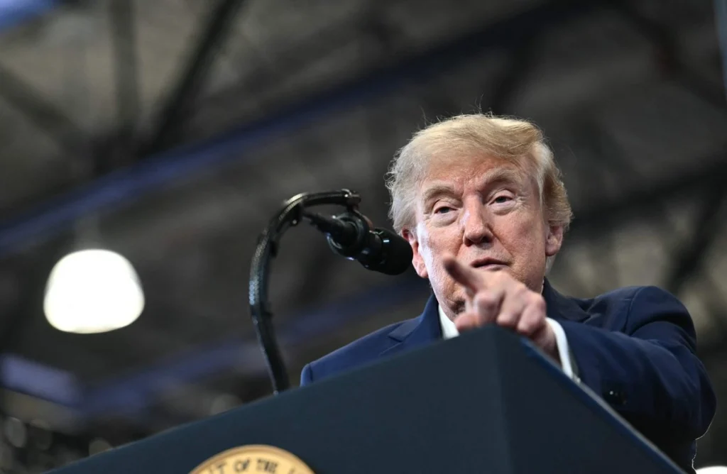 Donald Trump en un podio, señalando con el dedo.