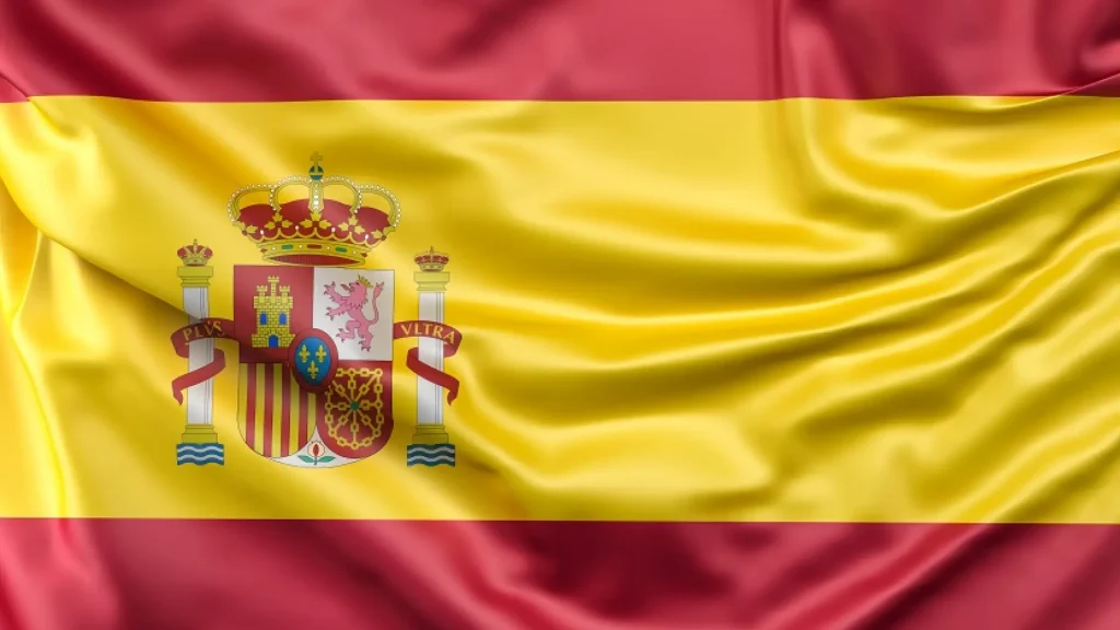 Bandera de España ondeando con su escudo nacional.