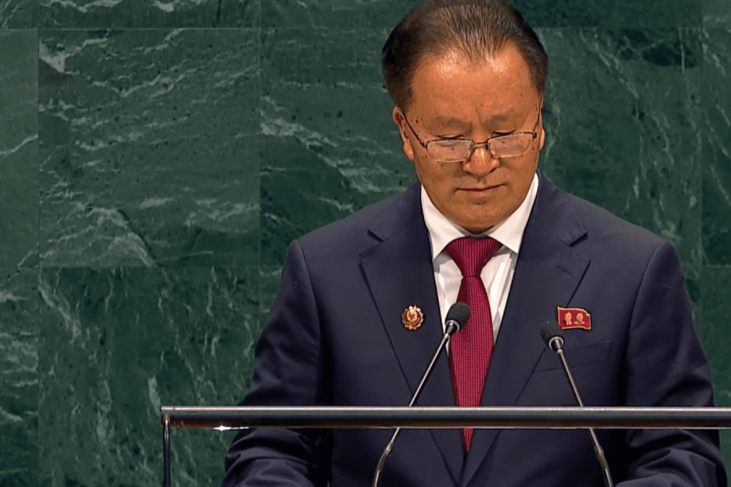 Dignatario asiático hablando en podio de la ONU con traje y corbata.
