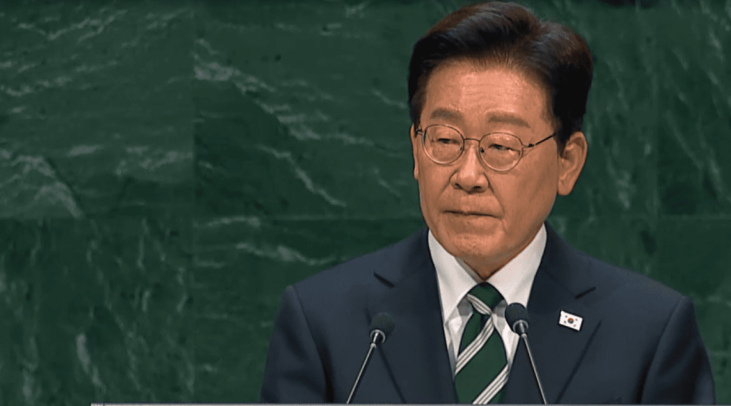 Político coreano con traje y corbata dando un discurso.