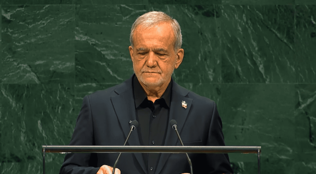 Hombre maduro con traje oscuro y ojos cerrados en podio.