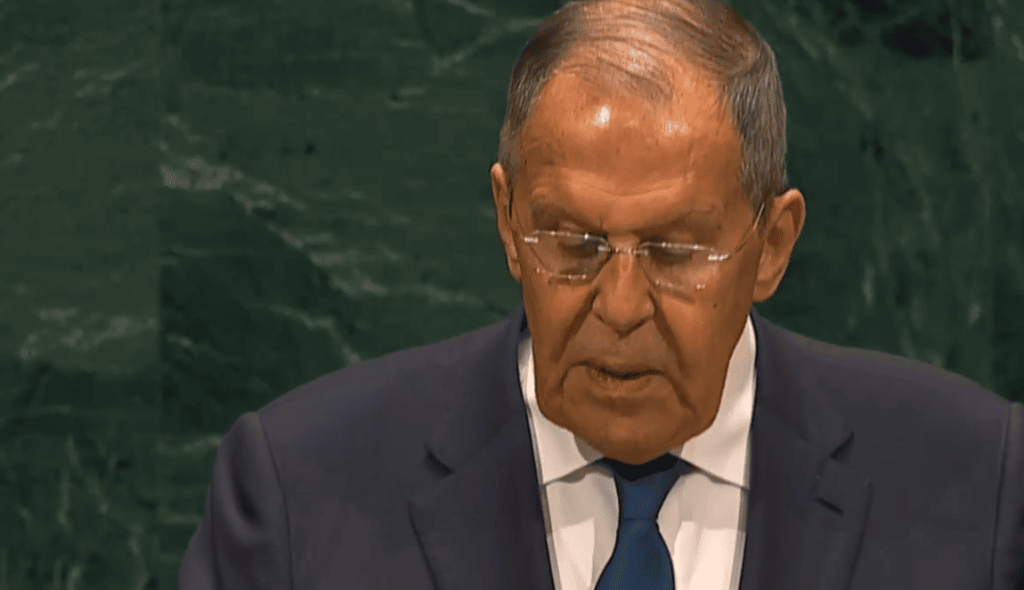 Sergey Lavrov hablando en conferencia oficial, traje y corbata azul.