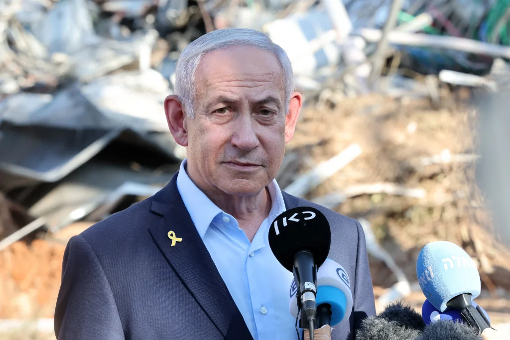 Netanyahu habla a la prensa con cinta amarilla en zona de escombros.