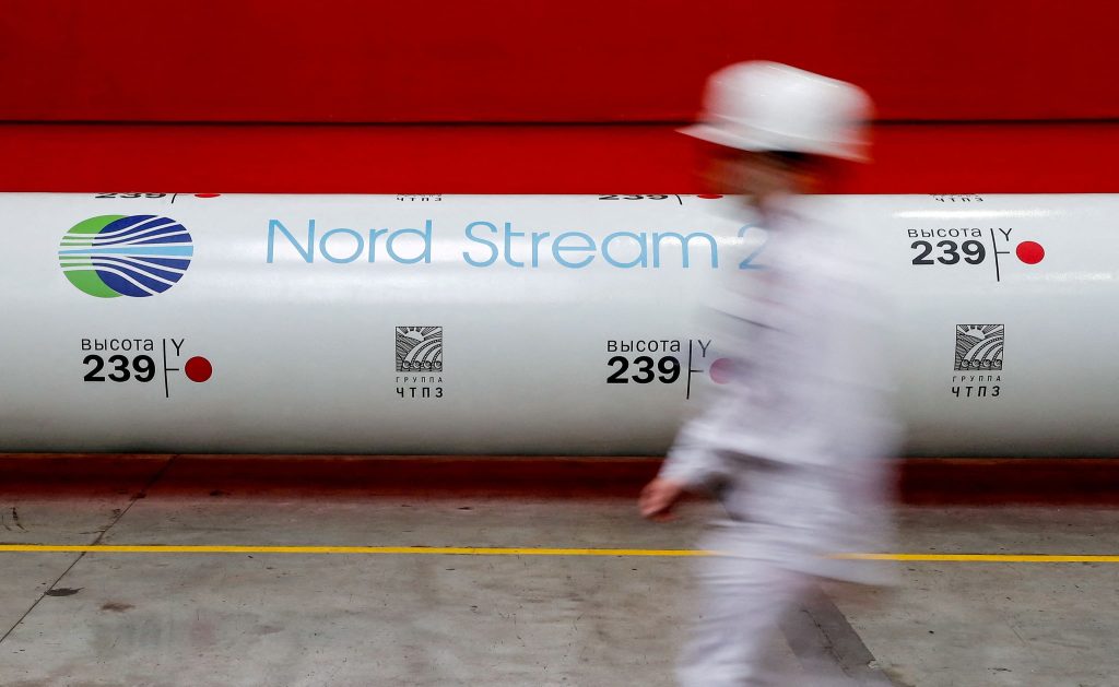 Trabajador junto a tubo Nord Stream 2 en fábrica.