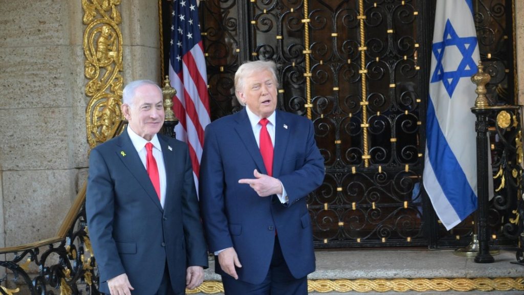 Netanyahu y Trump frente a banderas de EEUU e Israel.
