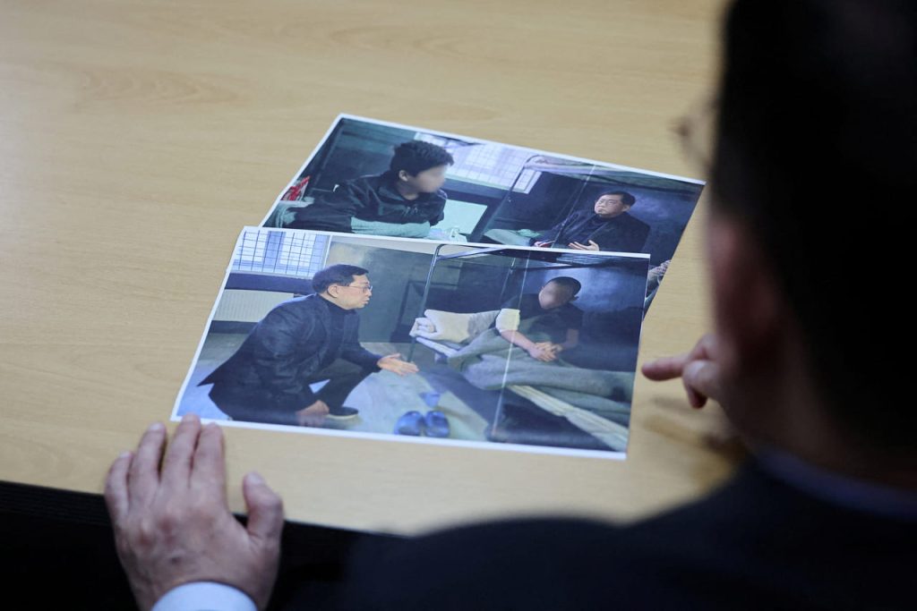 Persona examinando fotos de entrevistas y detención en una celda.